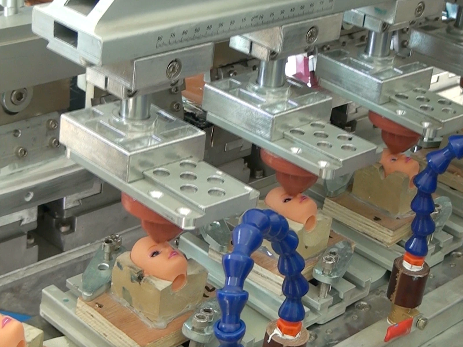 The pad printing and coloring of the heads for the customer-customized vinyl figures are in progress