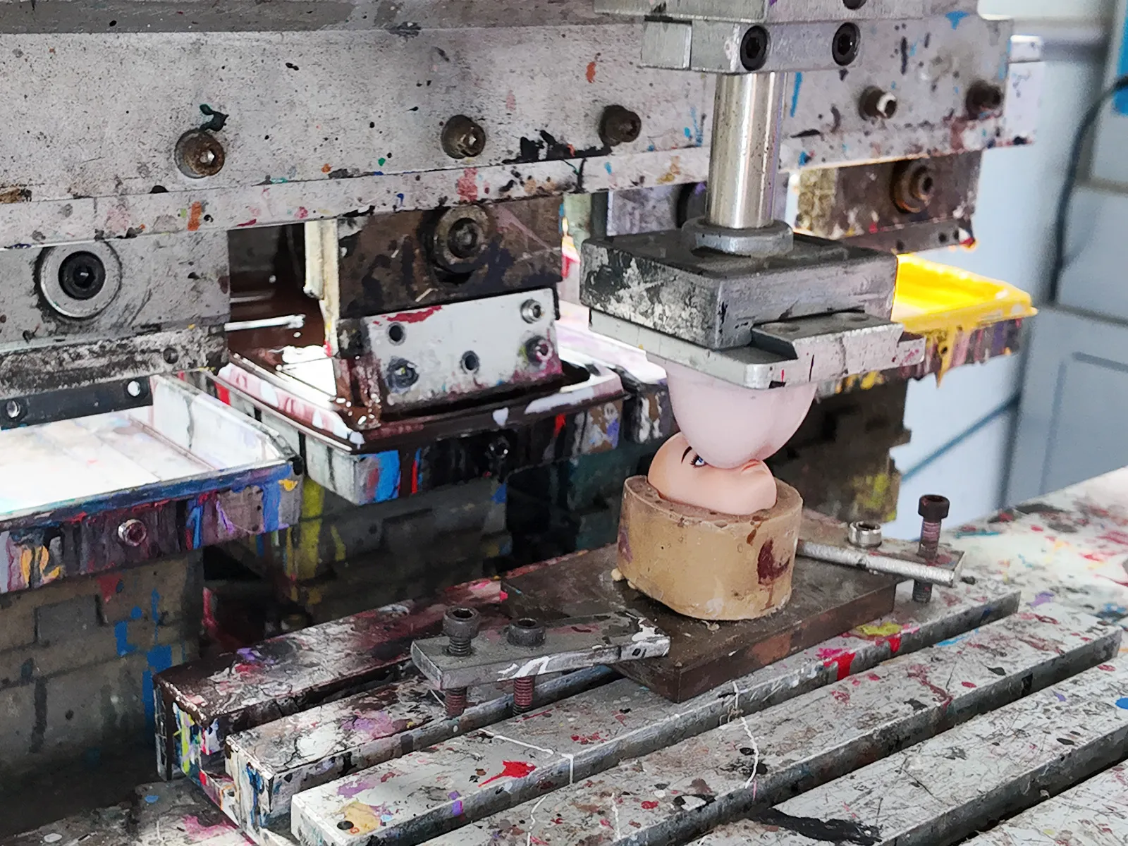 Single-head pad printing machine is applying blush to the face of the vinyl figure.