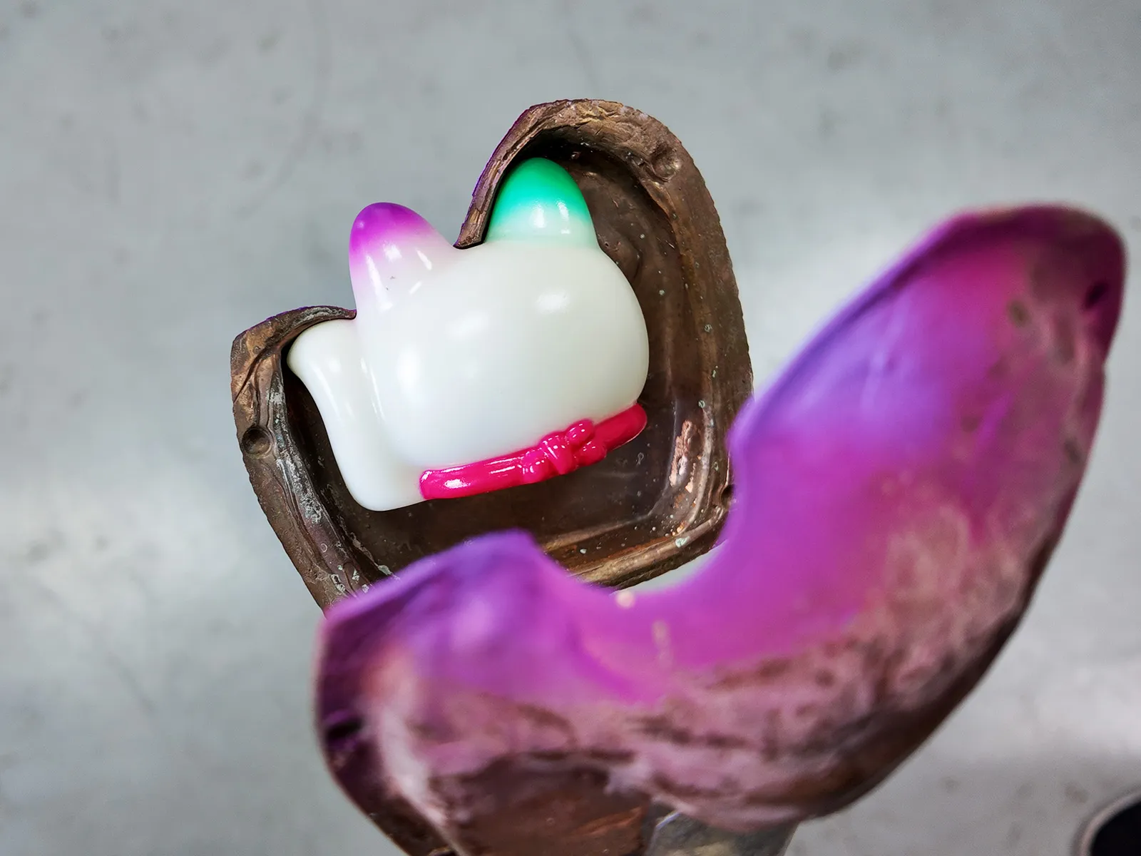 Vinyl toy painting process: using metal clamps to expose the ears for manual spraying.